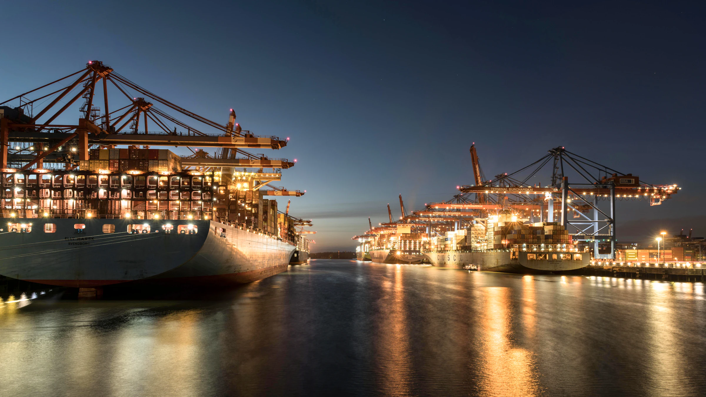 Container terminal at night with ship-to-shore cranes loading a vessel